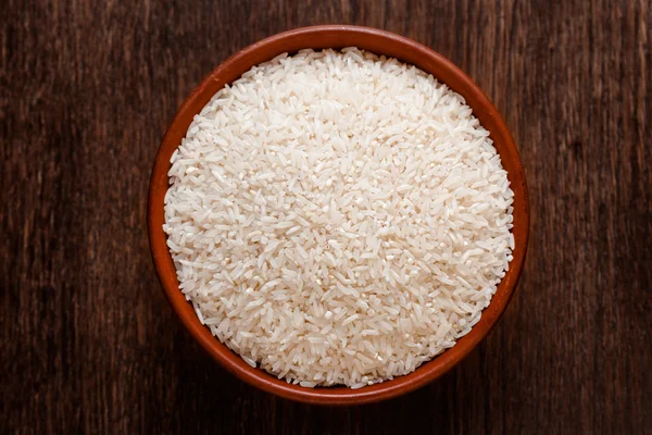 Yukarıdan koyu renkli ahşap izole çiğ çiğ beyaz pirinç Rustik Seramik kase