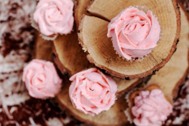 Ahşap arka plan üzerinde pembe krema ile cupcakes. 