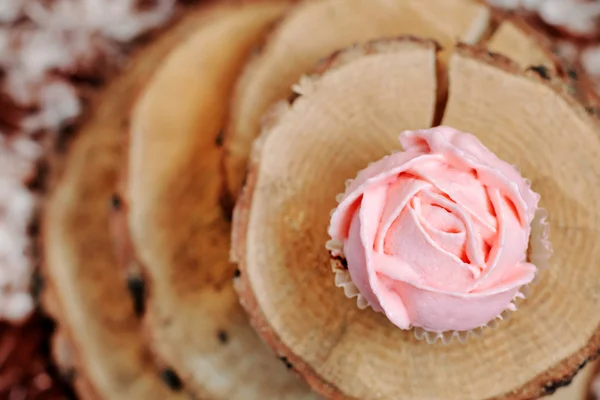 Cupcakes com creme rosa no fundo de madeira . — Fotografia de Stock
