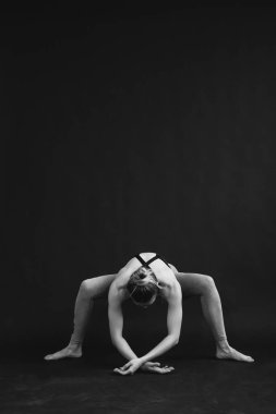 Yogacı kızın Asana 'yı sahnelediği siyah beyaz bir fotoğraf..