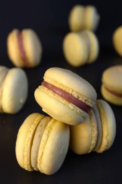 Siyah zemin üzerinde muz sarısı badem kurabiyeleri