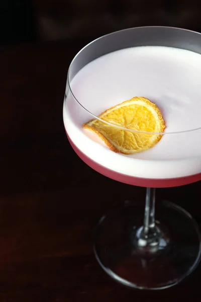 Pink cocktails at bar in nightclub party. Cocktails on black background in glass glasses.