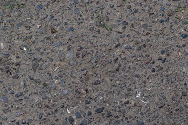 Asphalt texture with embedded rocks creates a versatile backdrop. Ideal for construction, urban designs, or textured backgrounds. Use for realistic detail.