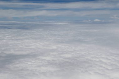 Mavi gökyüzünün altında ince bulut oluşumlarıyla engin beyaz bulutlar..