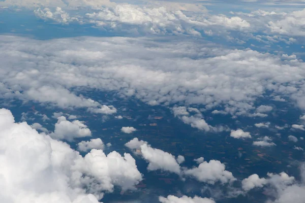 Mavi okyanus ve karaya dağılmış beyaz kümülüs bulutlarının çarpıcı hava manzarası doğal güzellik ve sükunet sergiliyor..