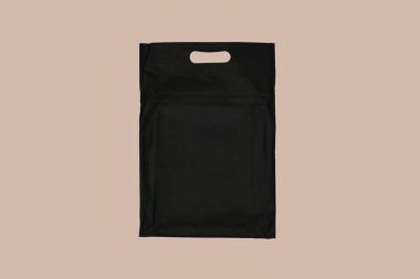 Sade bej arka planda saplı siyah çanta. Alışveriş için ideal ve günlük taşınma.