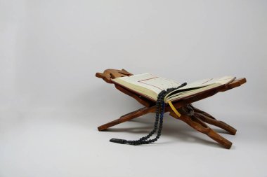 Renkli Tasbih ve Yer İmleriyle Tahta Dualar standı üzerine Kur 'an Aç. Ramazan ve İslami kavram.