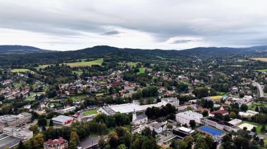 Büyüleyici bir hava perspektifi, huzurlu ve büyüleyici bir kasabayla birlikte yemyeşil tepeleri gözler önüne seriyor.