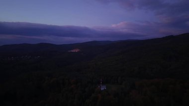 Alacakaranlıkta yuvarlanan tepelerin sakin ve nefes kesici manzarası sakin bir atmosferde nefes kesici renkler sergiliyor.