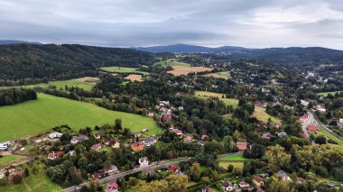 Havadan çekilen bir görüntü yeşil tarlaların nefes kesen manzarasını ve manzaralı tuhaf evleri yakalar.