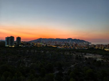 Experience a breathtaking view of a stunning coastal city, all beautifully bathed in serene sunset hues