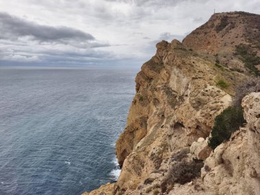 Sakin bir denizin ve kasvetli bir gökyüzünün üzerinde heybetli uçurumlar yükselir. Tüm ihtişamıyla muazzam güzellikleri sergiler.