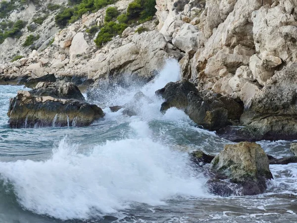 Dinamik ve güçlü deniz dalgaları çarpışıyor çarpıcı bir kıyı manzarasında engebeli kayalıklarla.