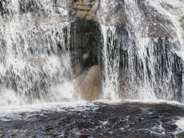 A stunning waterfall cascades over rugged terrain, creating a serene landscape perfect for relaxation