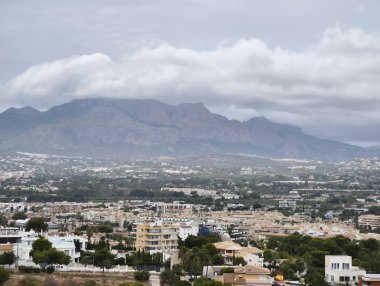 A picturesque landscape featuring mountains, a town, and a moody sky, perfect for nature and travel themes.