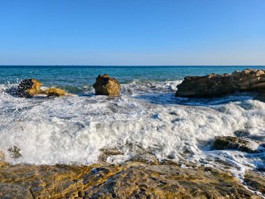 dalgalar ve kayalar denize