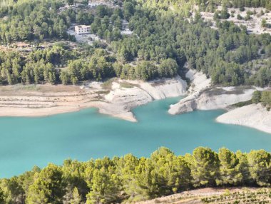 Nefes kesici bir hava manzarası serin mavi bir su deposunu sergiliyor. Etrafı yemyeşil ve canlı yeşilliklerle çevrili.