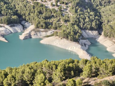 Canlı yeşillikler ve kayalık kıyılarla kucaklaşan dingin bir gölün nefes kesici hava manzarasıyla gözleriniz bayram etsin.