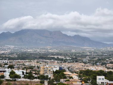 A picturesque landscape featuring mountains, a town, and a moody sky, perfect for nature and travel themes.