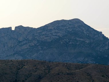 Görkemli bir dağ sırasının nefes kesici manzarası alacakaranlık karanlığında güzel bir şekilde siluete bürünmüş.