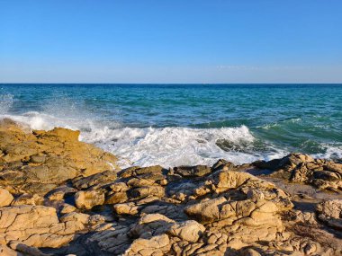 Çevresel kıyı sahnesi, doğal desenli kayalık arazide gelgit aşınma şekilleri gösteriyor.