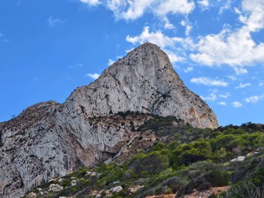 Ufkun ortasında kireçtaşı zirvesi, görkemli kireçtaşı zirvesi seyrek bitki örtüsünün ve gökyüzünün üzerinde yükseliyor.