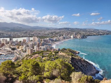 Turkuaz körfezdeki otellerin havadan görünüşü, dağ arkaplanı ve yemyeşil panoramik deniz manzarası