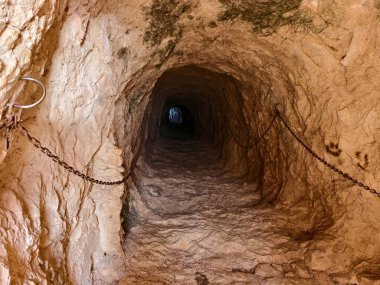 Karanlık kayalık tünellerde yıpranmış zincirler asılı, kasvetli kayalık tünellerde yaşlanmış zincirler asılı.