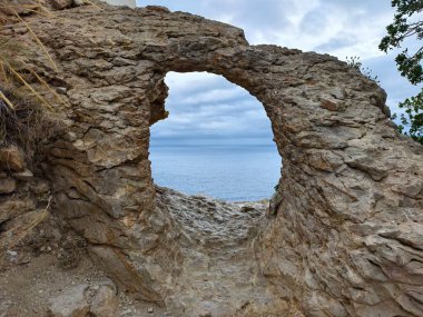 Taş çerçeve uzak okyanusu, desenli taş pencereyi gösteriyor. Fotoğrafçılara eşsiz bir deniz kenarı sunuyor.