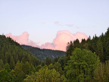 Tepelerin üzerinde sakin günbatımı, sakin dağ günbatımı pembe bulutlar ve sakin bir çevre.