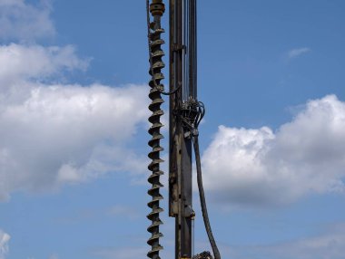 Görünür yıpranmış çelik yelek, devasa spiral auger metalik endüstriyel hassasiyet gösteriyor.