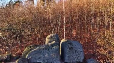 Yapraksız çalılıklara bitişik taş çıkıntısı, engebeli taşlar ve çıplak taşlarla sakin doğal manzara