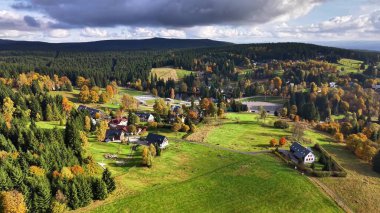 Değişik manzaralı huzurlu bir kırsal bölge, dingin ağaçların arasına yerleşmiş ve dalgalı bir köy.
