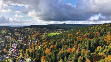 Sonbahar tepe örtüsü ve çatıları üzerindeki köy hava görüntüsü, Bulutlar Bulutları atarken arazi haritalama yerleşim desenleri