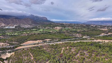Hava manzaralı engebeli dağ vadisi ve kıvrımlı nehir yoğun bulut altında kayalık tepeler, jeologlar