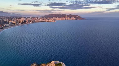 Sakin okyanus koyunda alacakaranlık yumuşak pastel gökyüzü, sakin mavi su, uzak aydınlık ufuk çizgisi, nazik