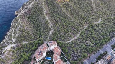 Havuzu olan uçurum üstü oteli, orman kenarına demirlemiş lüks kompleksi, dolambaçlı yol kıyı şeridine çıkıyor.,