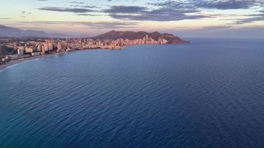 Sakin okyanus koyunda alacakaranlık yumuşak pastel gökyüzü, sakin mavi su, uzak aydınlık ufuk çizgisi, nazik