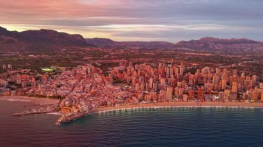 Hava manzaralı sahil kenti gün batımında aydınlatılmış sahil manzaralı ve dağ manzaralı, turizm panosu