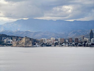 Uzak dağları ve geniş sakin denizi olan geniş kıyılar alçak şehir kuşağı, katmanlı katmanların altındaki su hattında yer alır.