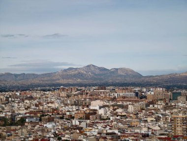 Uzak tepelere, terasotta fayanslarına ve karışık mimariye uzanan geniş çatılar.