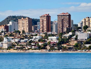 Körfeze ve kumlu kıyılara bakan lüks sahil kuleleri, modern yüksek yüzler ve tatil köyü atmosferi ideal.