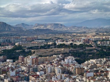 Yükseltilmiş perspektif, dokulu mahalle özellikleri ve yumuşak gökyüzü ile hareketli şehir ortamını yakalar