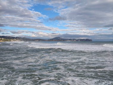 Sahilde doğal ortam ararken çekilen fotoğrafçı, bulutlu bir havada kıyı şeridini keşfediyor.