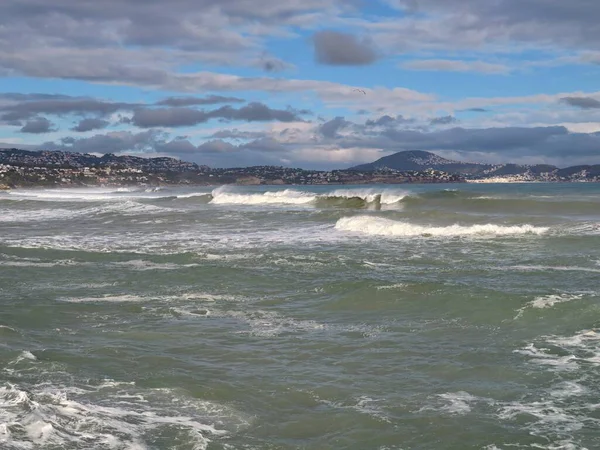 Yumuşak alacakaranlık dalgaları sessiz gökyüzü ve yumuşak yansımalarıyla körfez kıyısına doğru yuvarlanıyor, sakin akşam atmosferiyle