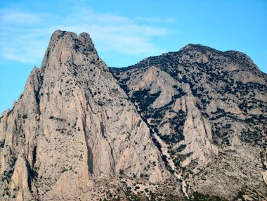 Gölgeli couloir granit yığınını kesiyor, dik koridor engebeli çıkıntılar ve derin gölgeler tarafından çerçeveleniyor, geç saatte