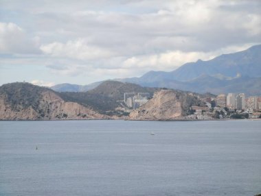 Sakin kıyı banliyöleri dağ sırtının altına yerleşmiş lowrise blokları ve açık körfez, sakin sular ve katmanlı katmanlar.