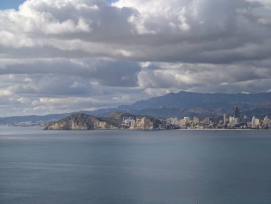 Kıyı şehri atmosferinin dramatik bulutları, yükselen bulutlar körfez ve kulelerin üzerine derin gölgeler bırakıyor.,