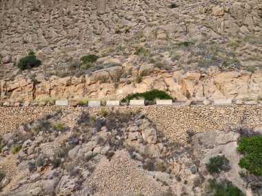 Dar geçitli, engebeli kaya yüzlü ve kuru ovalayıcılı beyaz arabalı sarp kayalık yol.