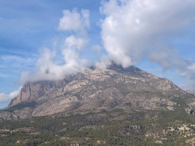 bulutlu dağ zirvesi dönen bulutlar, engebeli granit yüz ve dramatik gölgeler, dağ rehberi